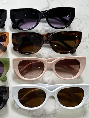 Blush pink and white sculpted cat eye sunglasses with brown gradient lenses.