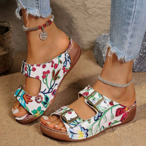 Floral double-strap buckle slides with adjustable straps and contoured footbed.