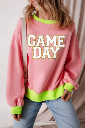 Blush pink sweatshirt with neon trim and glitter appliqué "GAME DAY" graphic.