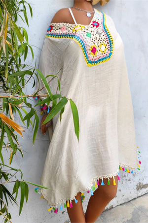 Beige kaftan dress with colorful crochet yoke and tassel trim.