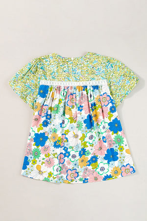 Floral patchwork puff sleeve blouse with smocked detail and white lace trim.