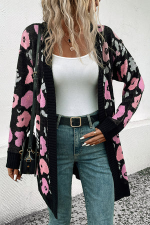 Black floral jacquard longline knit cardigan with pink and grey accents, open front, long sleeves.
