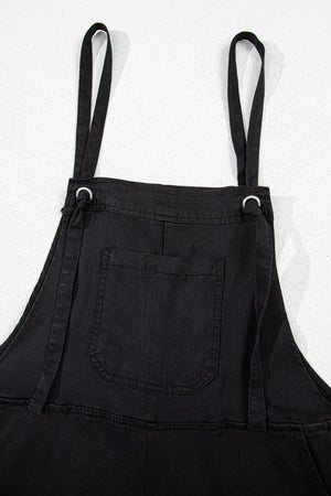 Black denim romper with adjustable straps and a front pocket.