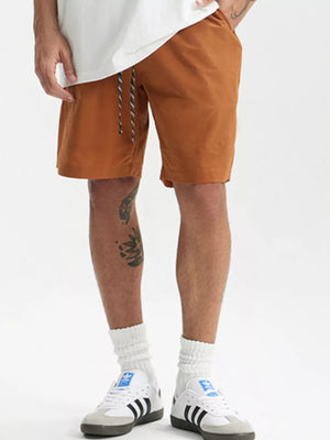 Men's terracotta chino shorts with drawstring and pockets.