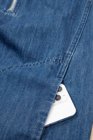 Denim shift dress with zip neck and side pocket holding a smartphone
