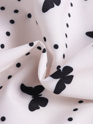White baby dress with black butterfly and polka dot print.