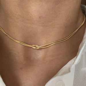 Gold serpent knot necklace with double chain detail