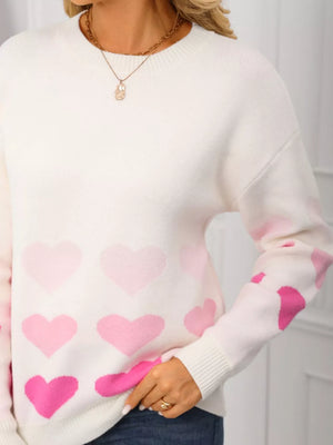 White acrylic crew neck sweater with allover pink heart print and ribbed cuffs.