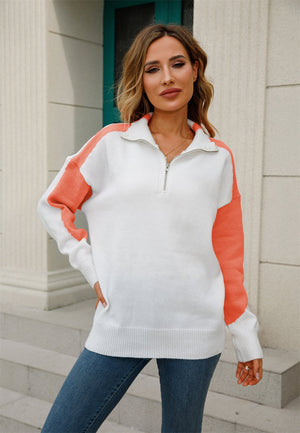 Colorblock zip-neck knit pullover sweater in white with orange sleeves and shoulder detail.