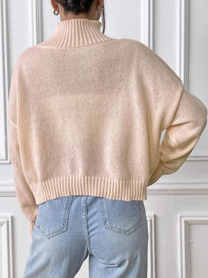 Blush pink knit turtleneck sweater with ribbed cuffs and hem, shown from the back.