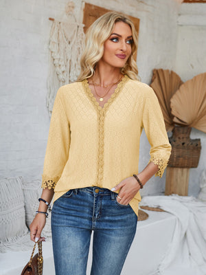Light yellow eyelet blouse with V-neck and lace trim details.