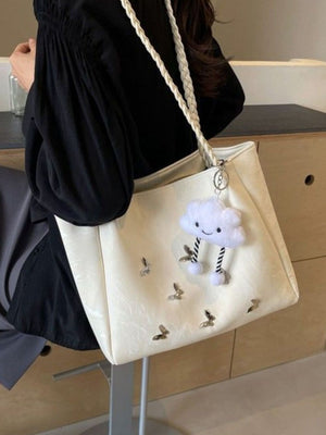 Cream shopper bag with braided handles, butterfly details, and cloud charm