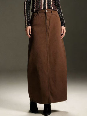 Brown denim maxi skirt with raw hem and button closure.