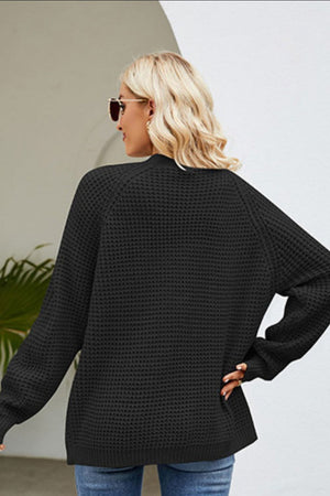 Black waffle knit acrylic cardigan with long sleeves and a relaxed fit.