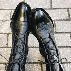 Black leather ankle boots with glossy cap toe and lace-up front.