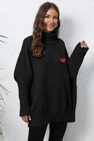 Black batwing knit turtleneck sweater with red heart embroidery and ribbed sleeves.