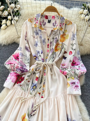Vibrant floral midi dress with lantern sleeves, button front, and tie waist.