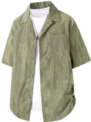 Relaxed fit military green camp collar shirt with button front and chest pocket, worn over a white tee.