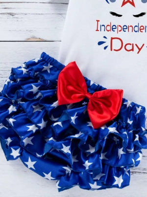 Ruffled baby bloomer shorts with white stars on blue fabric and a red bow.