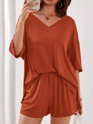 Orange-red V-neck two-piece lounge set with cuffed sleeves and drawstring shorts.