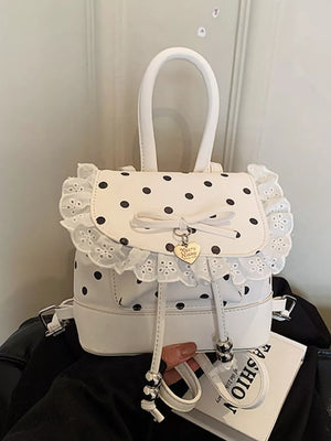 Cream white polka dot mini backpack with lace trim and bow detail.