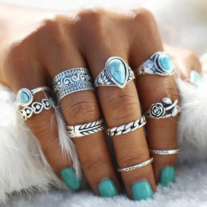 Bohemian silver ring stack with turquoise stones, featuring ornate and chain designs.