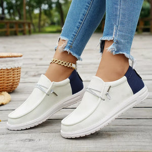 Chic two-tone casual slip-on shoes in white with navy accents and decorative laces.