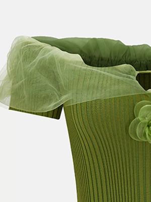 Green off-shoulder ruffled knit maternity t-shirt with floral detail and sheer overlay.