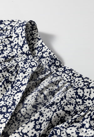 Blouse with navy and white floral print, featuring a notched neckline and gathered detail.