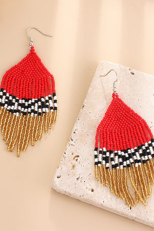 Red beaded earrings with black, white, and gold fringe detail.