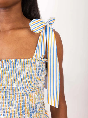 Smocked bodice set with rainbow stripe tie straps and ruffled neckline.
