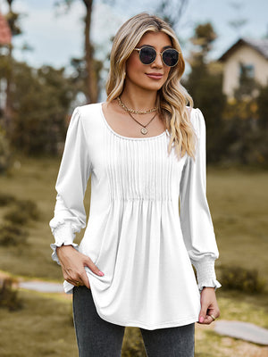 White peplum blouse with gathered yoke and smocked cuffs.