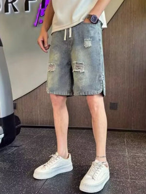 Distressed denim shorts with adjustable drawstring and ripped details.