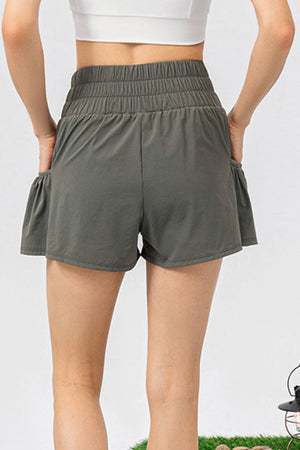 Gathered waistline active shorts in matcha green with ruffled pockets.