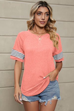 Raglan sleeve tee in watermelon pink with varsity stripes on sleeves and contrast stitching.