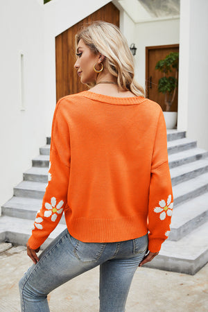 Daisy Sleeve Knit Cardigan in Pumpkin orange with white daisy pattern on sleeves.