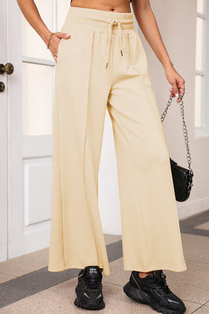 Palazzo joggers in Pastel Yellow with drawstring waist and center seam detail.