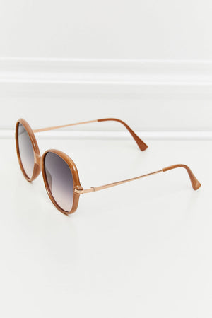 Oversized round frame sunglasses in caramel with gradient lenses and thin rose gold metal arms.