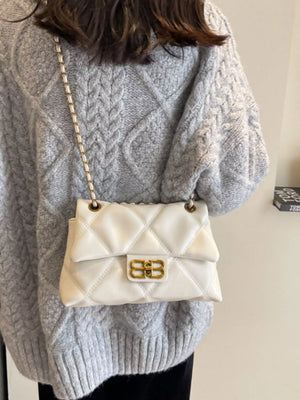 White quilted flap chain shoulder bag with gold hardware and a classic clasp.