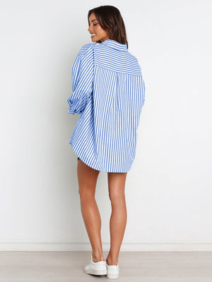 Oversized light blue and white striped shirting with button front, worn with shorts.