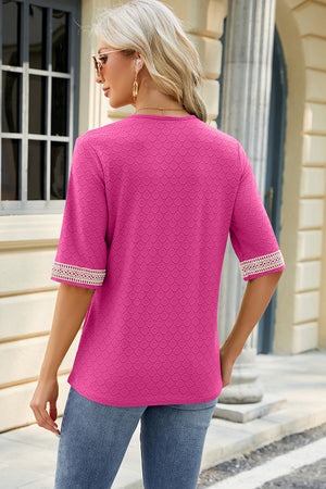 Hot pink textured v-neck blouse with lace trim on sleeves.