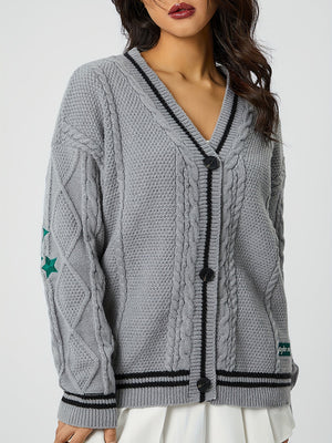 Gray cable knit cardigan with black stripe V-neck and green stars on sleeve.