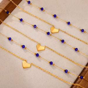 Gold layered necklace with blue beads and heart pendants
