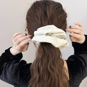 Quilted faux leather scrunchie in beige with diamond pattern detail.