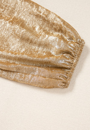 Gold peplum blouse with ruched sleeve detail and shimmering fabric.