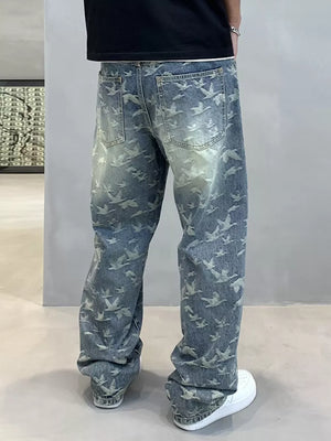 Loose-fit denim jeans with all-over bird print and distressed wash.