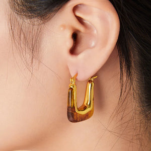 Gold geometric hoop earrings with amber resin detail