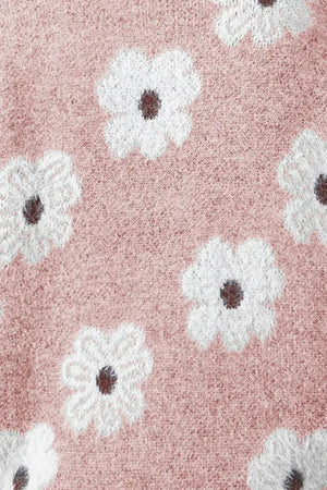 Blush pink acrylic sweater with white floral intarsia pattern and dark centers.