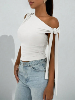 White asymmetrical tie detail cropped blouse with one shoulder and tie sleeves.
