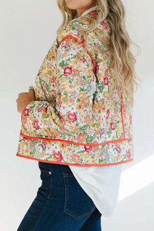 Floral quilted jacket with contrast piping in orange-red, featuring a vibrant floral print and casual cut.